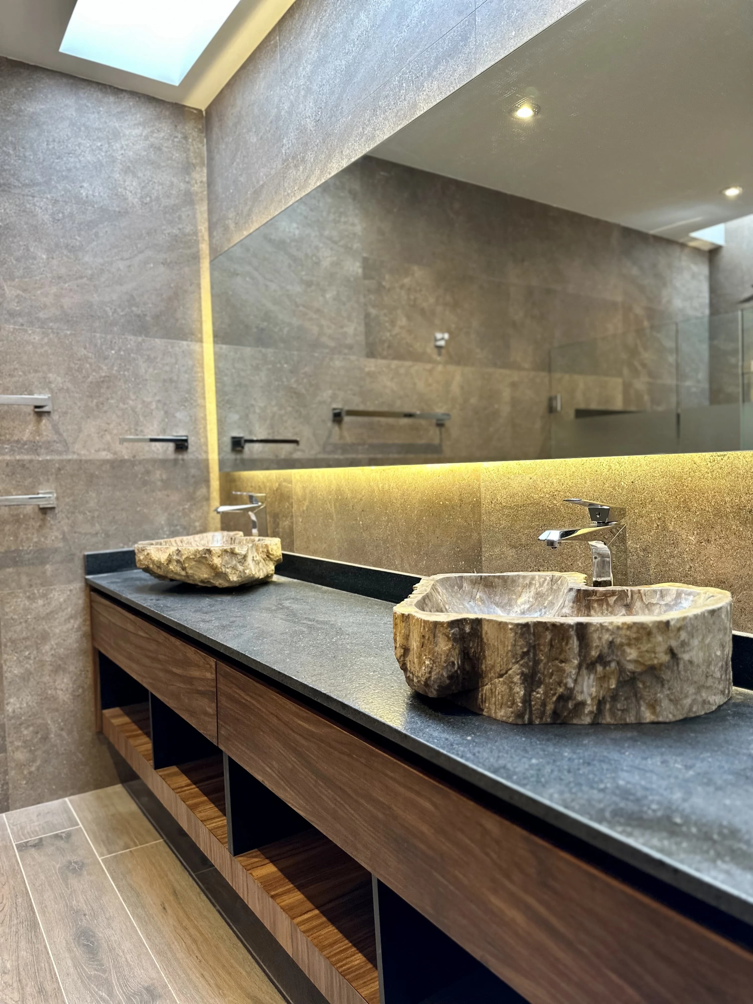 Baño de Casa del Ángel con dos lavabos de piedra sobre mueble de madera