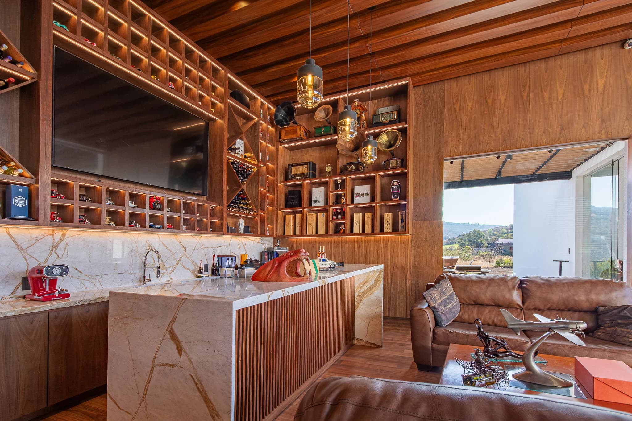 Bar de L&C con cava de vino en madera, barra de mármol y sala de piel