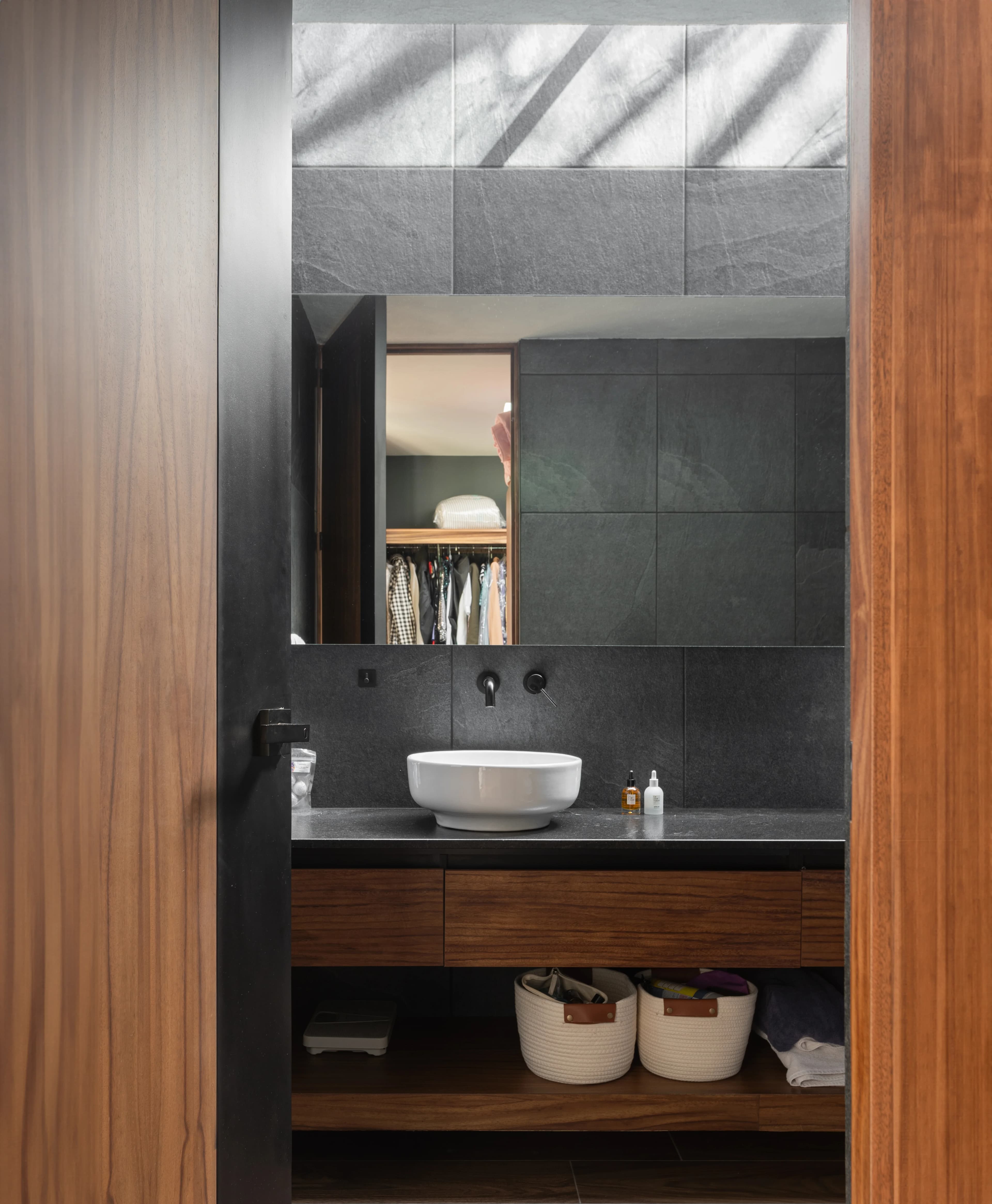 Baño de Casa Zorros con lavabo de piedra y cancelería de madera