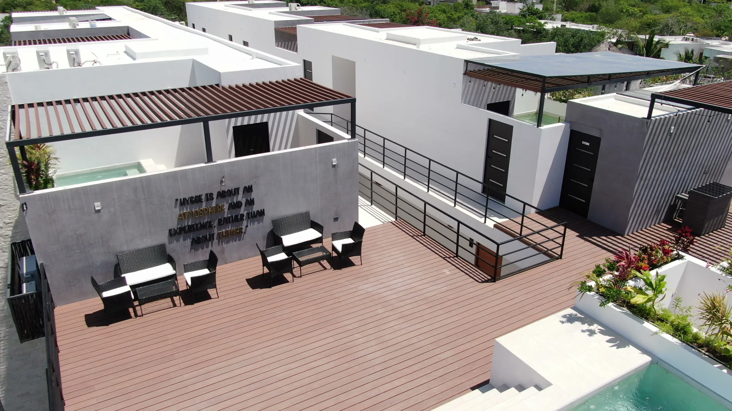 Terraza social del rooftop de Hygge, con el logotipo de la marca en el muro